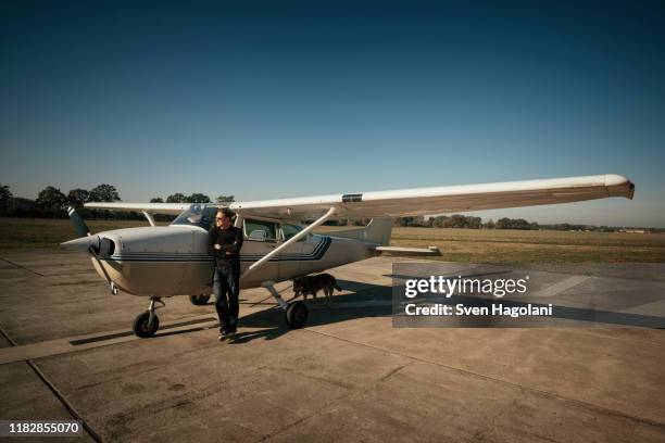 male pilot standing at small propellor airplane on sunny tarmac - 1 minute 50 stock pictures, royalty-free photos & images