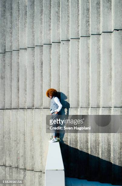 view from above young man with afro laying on sunny urban steps - ângulo diferente imagens e fotografias de stock