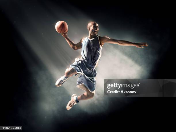 basketball player performs slam dunk - slam-dunk-photos stock pictures, royalty-free photos & images