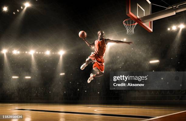 basketball player performs slam dunk - slam dunk stock pictures, royalty-free photos & images