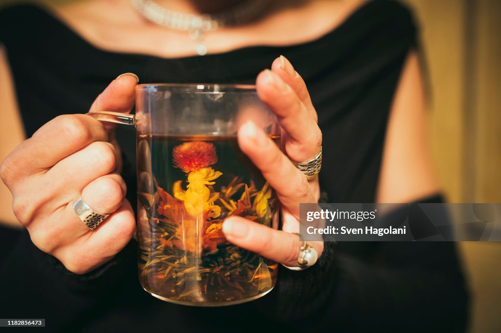 Close up woman drinking blooming tea