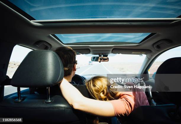 affectionate couple riding in sunny car - 40s couple sunny stockfoto's en -beelden