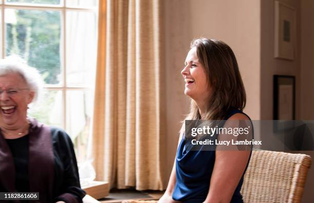 two women at a counseling session, laughing with their mouths open - elderly cognitive stimulation therapy stockfoto's en -beelden