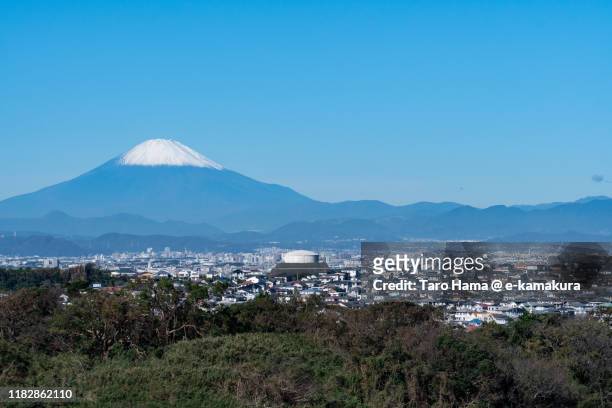 snow-capped mt. fuji and the residential district in kanagawa prefecture of japan - chigasaki stockfoto's en -beelden