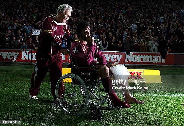 Johnathan Thurston of the Maroons is pushed onto the field in a wheelchair after the match after injuring his knee during game three of the ARL State...