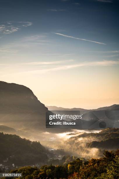 sonnenaufgang morgennebel im kleinen dorf an den italienischen alpen, piemont, monte fenera - region piemont stock-fotos und bilder