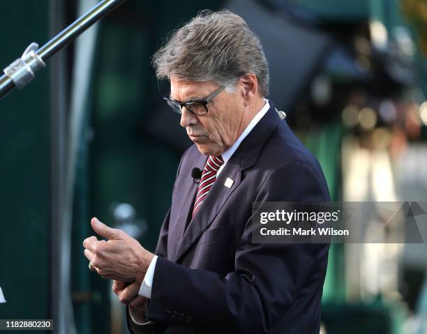 Secretary of Energy Rick Perry looks at his phone before appearing on a morning television show, at the White House on October 23, 2019 in...