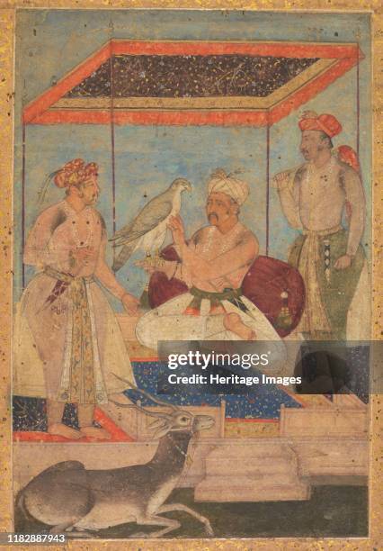Akbar and Jahangir Examine a Ghir Falcon while Prince Khusrau Stands Behind, circa 1602-1604. Emperor Akbar sits against a purple bolster under a...