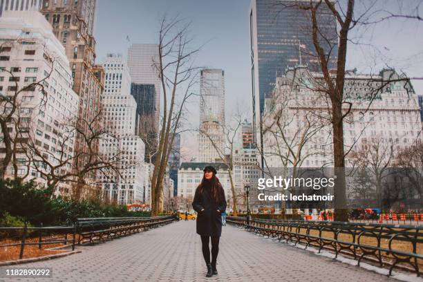 giovane donna che cammina nel parco centrale di new york in inverno - autumn in new york foto e immagini stock