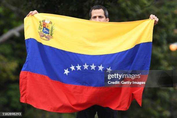 Opposition leader Juan Guaido, recognized by many members of the international community as the country's rightful interim ruler, waves a Venezuelan...