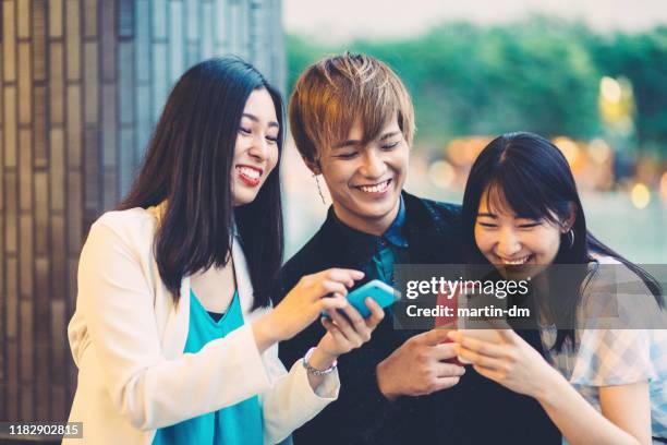 young japanese people enjoying modern technologies - telephone game stock pictures, royalty-free photos & images