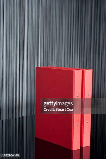 two red a4 ring binder folders on a black glass desktop - a4 folder stock pictures, royalty-free photos & images