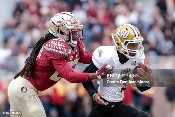 Runningback Duran Bell of the Alabama State Hornets is tackled from behind by Safety Akeem Dent of the Florida State Seminoles during the game at...