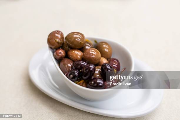 directly above shot of variety of olives in bowl on white background - kalamata olive fotografías e imágenes de stock