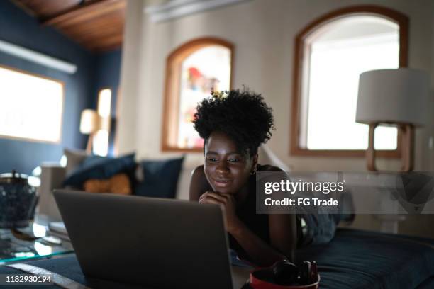 jeunes femmes regardant le film sur un ordinateur portatif à la maison - movie film reel photos et images de collection