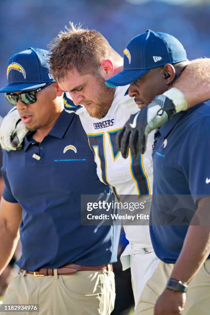 Forrest Lamp of the Los Angeles Chargers is helped off the field after being injured during a game against the Tennessee Titans at Nissan Stadium on...