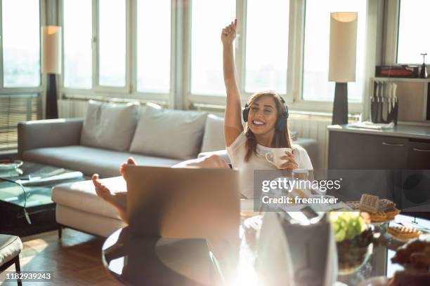 mooie jonge vrouw luisteren muziek in appartement - pyjama stockfoto's en -beelden
