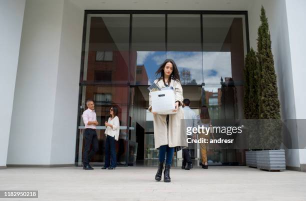 mujer despedida saliendo de la oficina con sus pertenencias en una caja - despedido fotografías e imágenes de stock