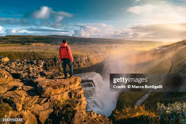 one man standing on top of gullfoss waterfall, iceland - cultura islandesa fotografías e imágenes de stock