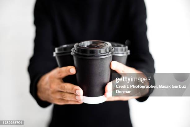 an unrecognizable man holding three disposable and black paper coffee cups with lids on - number three stock pictures, royalty-free photos & images