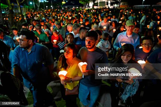 Catholic faithful participate in a procession to commemorate the 30th anniversary of the murder of six Jesuit priests and two employees, in San...