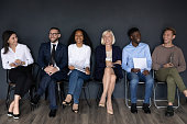 Happy multiracial businesspeople group sit on chairs laughing, human resource