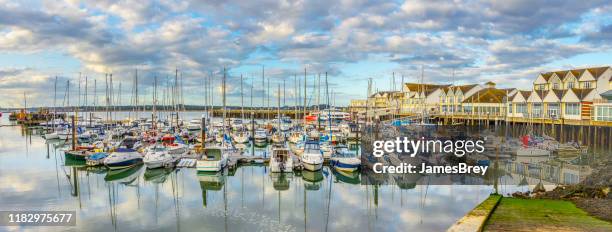 marina and harbor in southampton, uk, with tranquil waters reflecting clouds, sky. - southampton inglaterra imagens e fotografias de stock