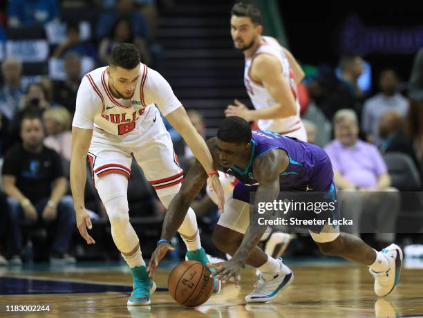 Zach LaVine of the Chicago Bulls and Dwayne Bacon of the Charlotte Hornets go after a loose ball during their game at Spectrum Center on October 23,...