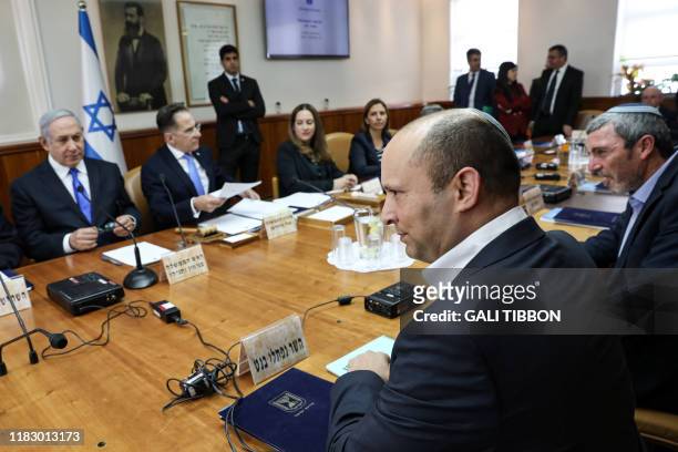 Israeli Prime Minister Benjamin Netanyahu looks at his new Defence Minister Naftali Bennett at the start of the weekly cabinet meeting at his...