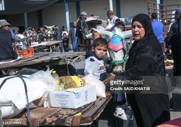 Palestinian women talks to a child after receiving food aid from a United Nations Relief and Works Agency distribution centre in the southern Gaza...