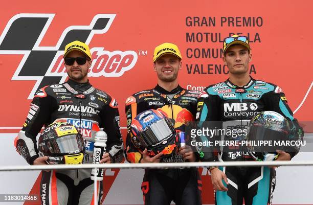 Winner Red Bull KTM Ajo's rider Brad Binder poses alongside second placed Dynavolt Intact's Swiss rider Thomas Luthi and third placed Beta Tools...