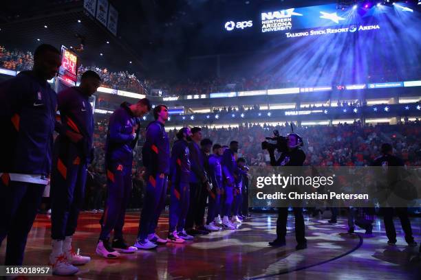 The Phoenix Suns stand attended for the national anthem before NBA game against the Sacramento Kings at Talking Stick Resort Arena on October 23,...