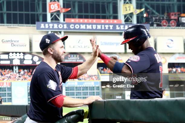 Victor Robles of the Washington Nationals is congratulated by his teammate Brian Dozier after scoring a run against the Houston Astros during the...