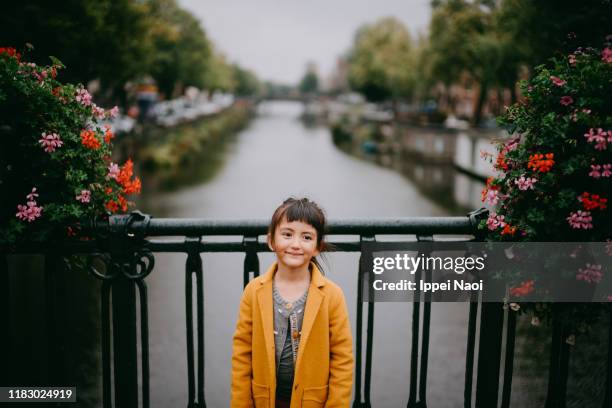 cute mixed race young girl with canal in amsterdam - eurasische herkunft stock-fotos und bilder