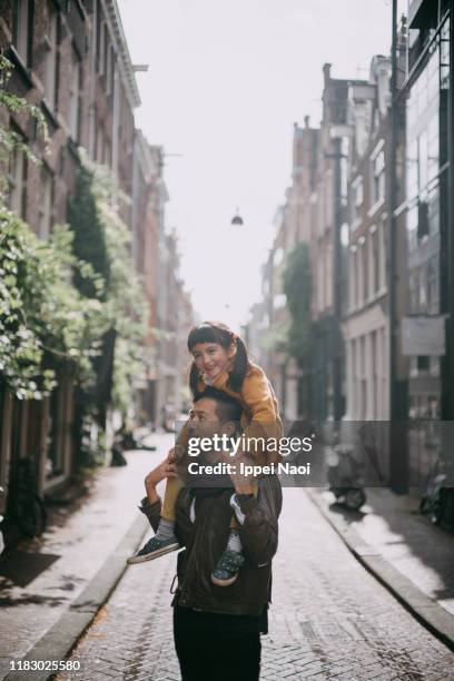 father carrying preschool daughter on his shoulders, amsterdam - amsterdam winter stock pictures, royalty-free photos & images