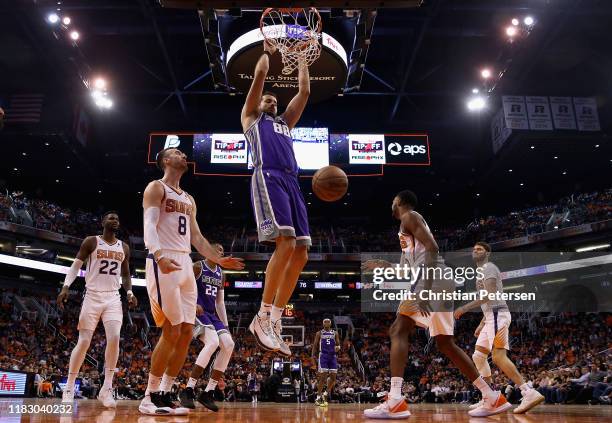 Nemanja Bjelica of the Sacramento Kings slam dunks the ball against Frank Kaminsky of the Phoenix Suns during the second half of the NBA game at...