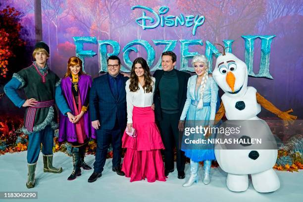 Actor Josh Gad , US actor Idina Menzel and US actor Jonathan Groff pose with people dressed as characters from the film on the red carpet as they...