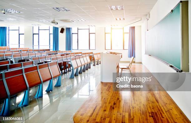 desks and chairs in a lecture hall - empty classroom stock pictures, royalty-free photos & images