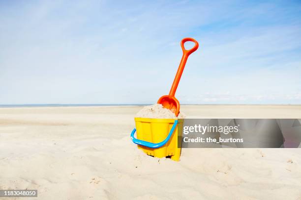 sand pail and shovel on beach - bucket and spade stock pictures, royalty-free photos & images