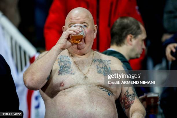 An England supporter drinks beer during the UEFA Euro 2020 qualifying Group A football match between Kosovo and England at the Fadil Vokrri stadium...