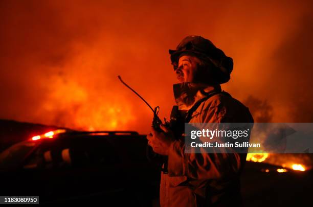 Firefighter monitors the Kincaide Fire as it burns through the area on October 24, 2019 in Geyserville, California. Fueled by high winds, the...