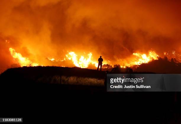 Cal Fire firefighter monitors the Kincaide Fire as it burns a hillside on October 24, 2019 in Geyserville, California. Fueled by high winds, the...