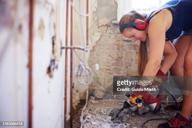 woman doing demolition in her house. - wiederbelebung stock-fotos und bilder