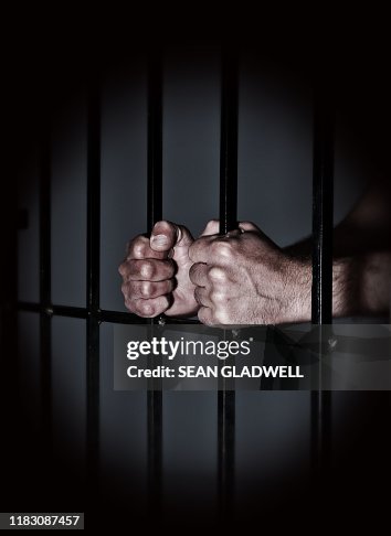 Prisoner behind prison bars Prisoner behind prison bars