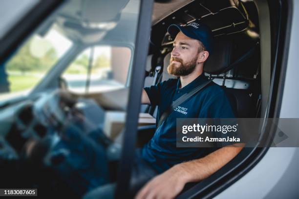 young male gig driver waiting to get started on deliveries - uniform stock pictures, royalty-free photos & images