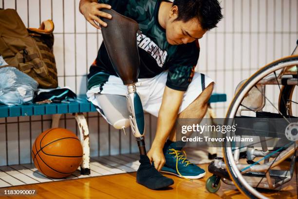 professional wheelchair basketball player putting on his - amputee rehab stock pictures, royalty-free photos & images