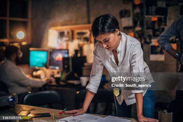 lady detective looking for clues on a crime case - mulher polícia imagens e fotografias de stock