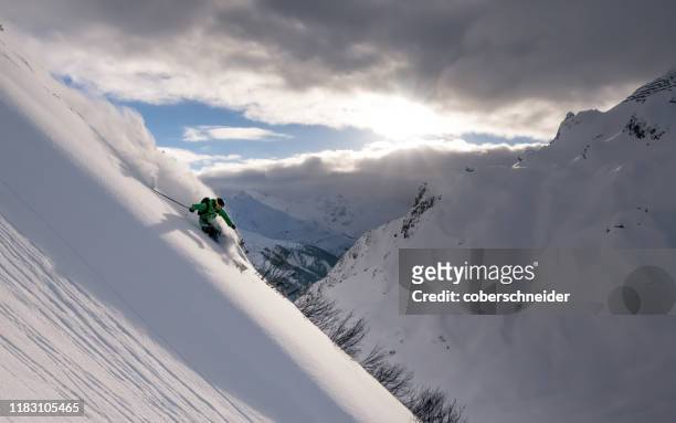 man skiing in deep powder snow in the austrian alps, austria - central eastern alps stock pictures, royalty-free photos & images