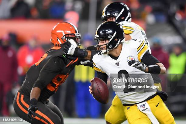 Quarterback Mason Rudolph of the Pittsburgh Steelers moves to avoid pressure from defensive end Myles Garrett of the Cleveland Browns in the second...