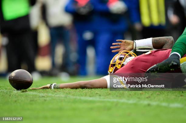 Dwayne Haskins of the Washington Redskins loses the ball after being sacked by Frankie Luvu and James Burgess of the New York Jets during the second...